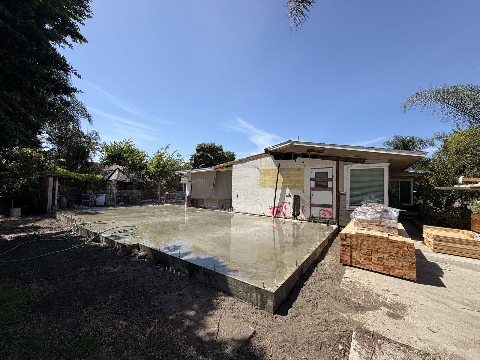 Poured ADU foundation slab with the main house's exterior wall opened up for the tie-in
