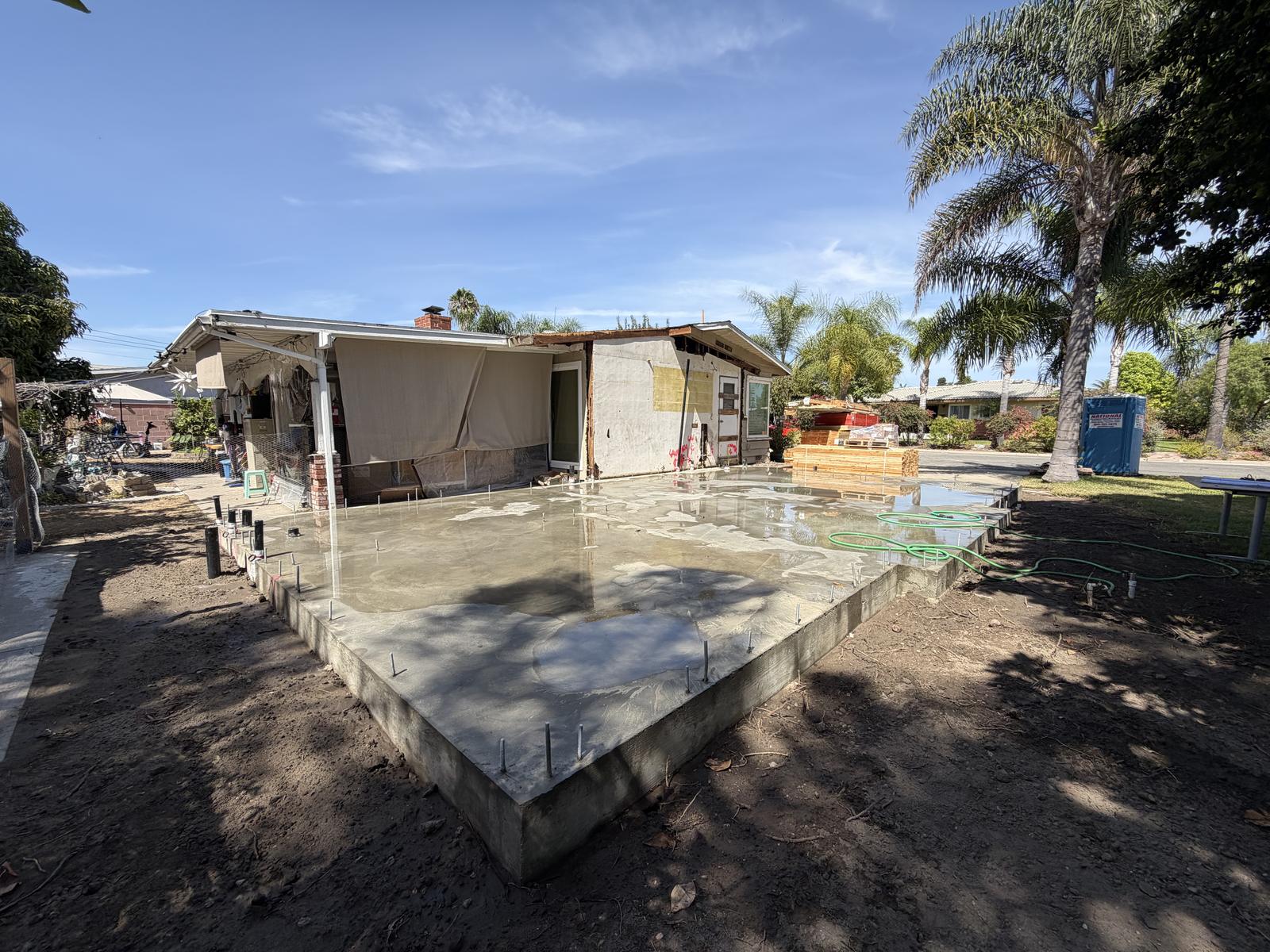 ADU exterior mid-construction with a freshly poured concrete patio slab