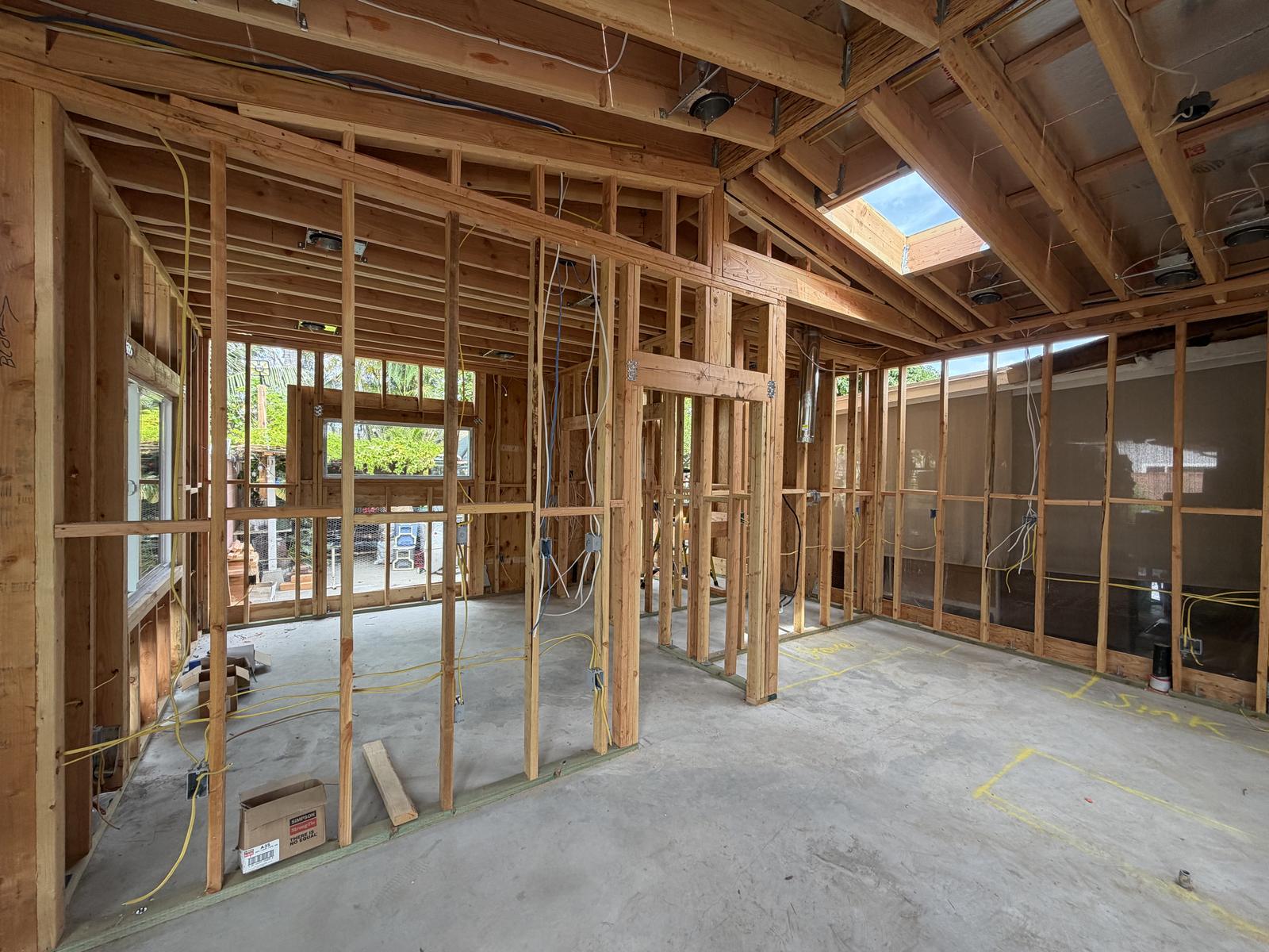 Open ADU interior framing with vaulted ceiling, skylight, and electrical rough-in