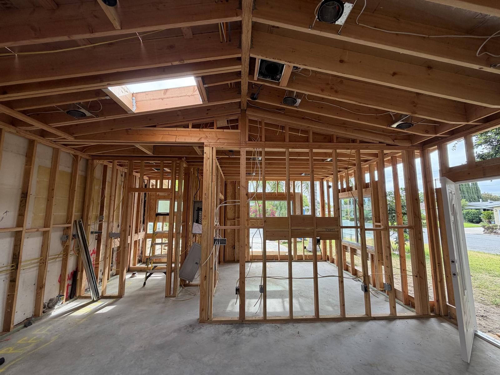 ADU interior framing with vaulted ceiling, skylight, and window openings on multiple walls