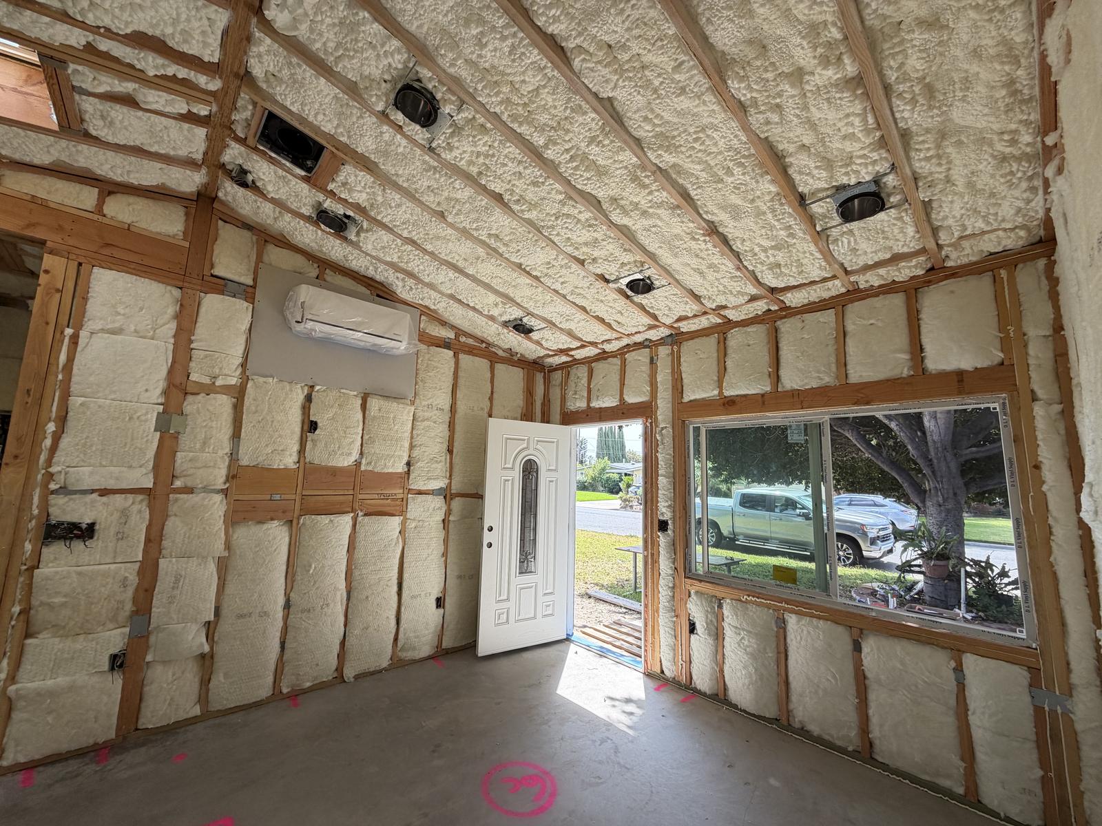 Insulated ADU room with a wall-mounted mini-split AC unit ready for finish work