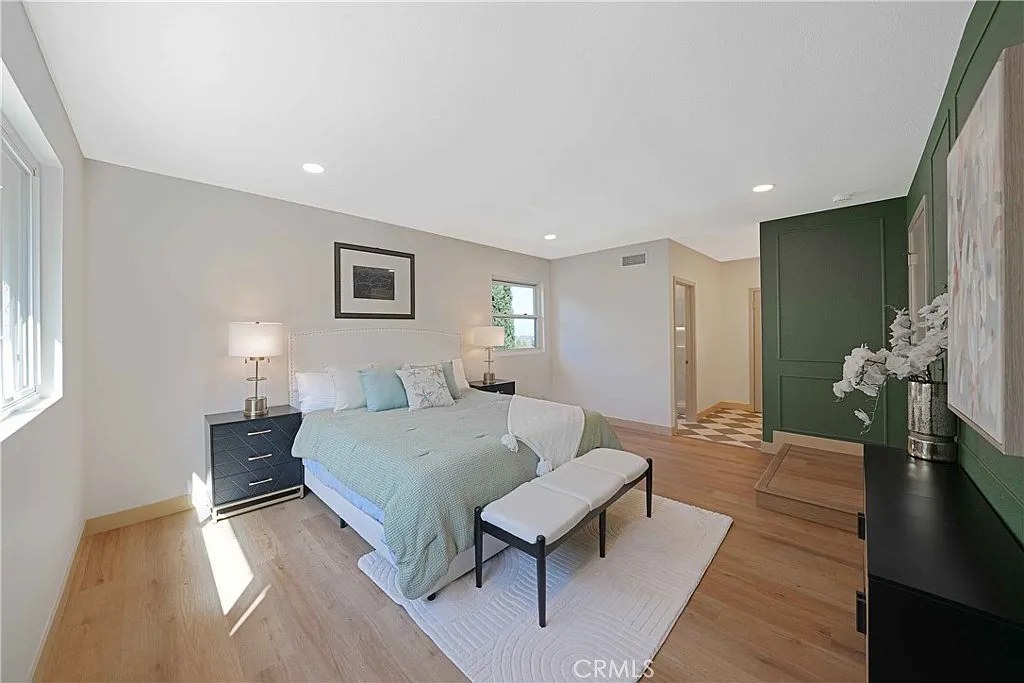 Primary bedroom with green accent wall, checkerboard tile nook, and en-suite bathroom entry