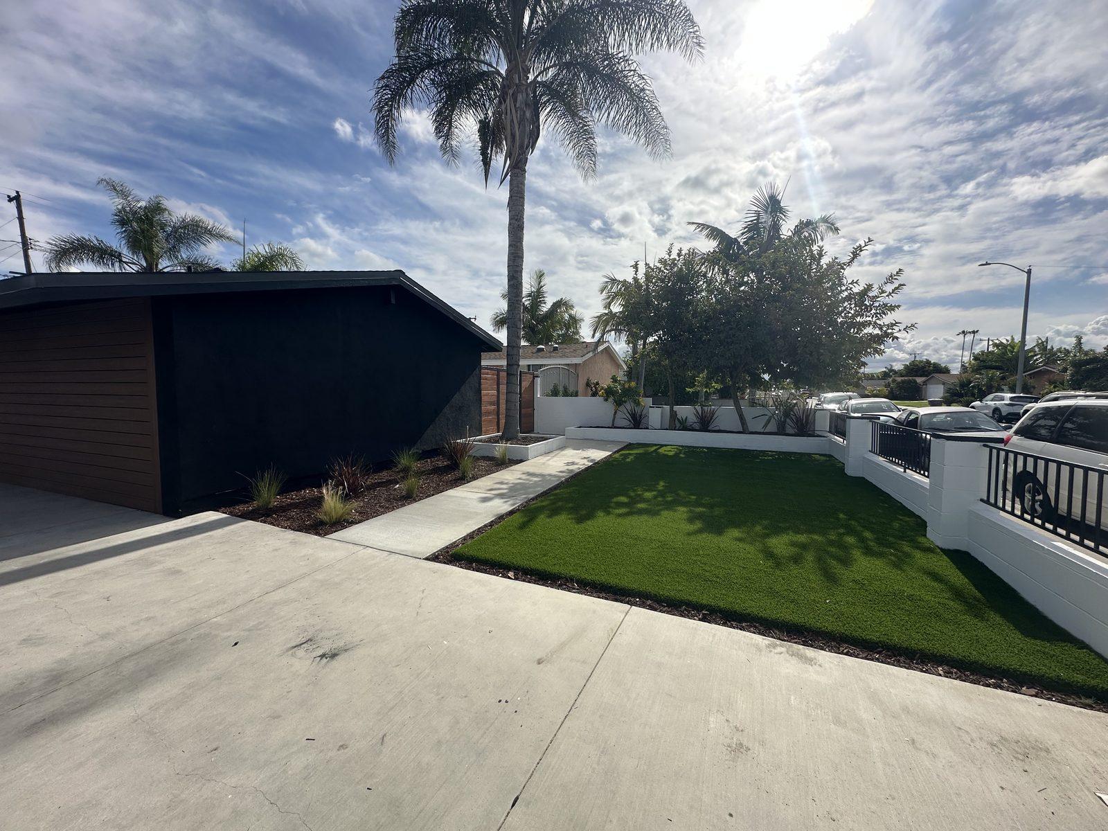 Front yard renovation with new artificial turf lawn and painted block perimeter wall