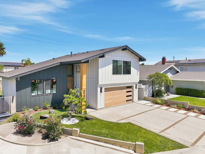 Aerial view of a remodeled home with fresh sod lawn, drought-tolerant planting beds, and a paver driveway