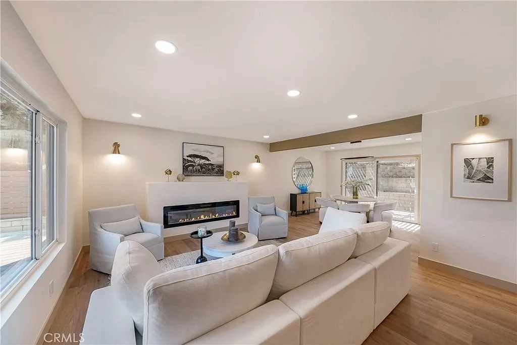 Living room with linear gas fireplace, light blue swivel chairs, and white sectional sofa